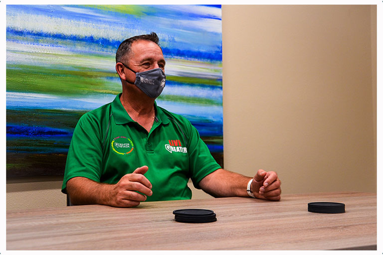 Wally Murry CEO of Greater Nevada Credit Union in a mask at a table.