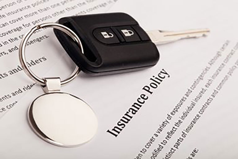 car key on top of insurance policy