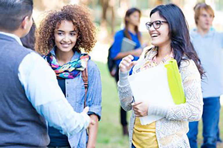 college girls speaking with male professor