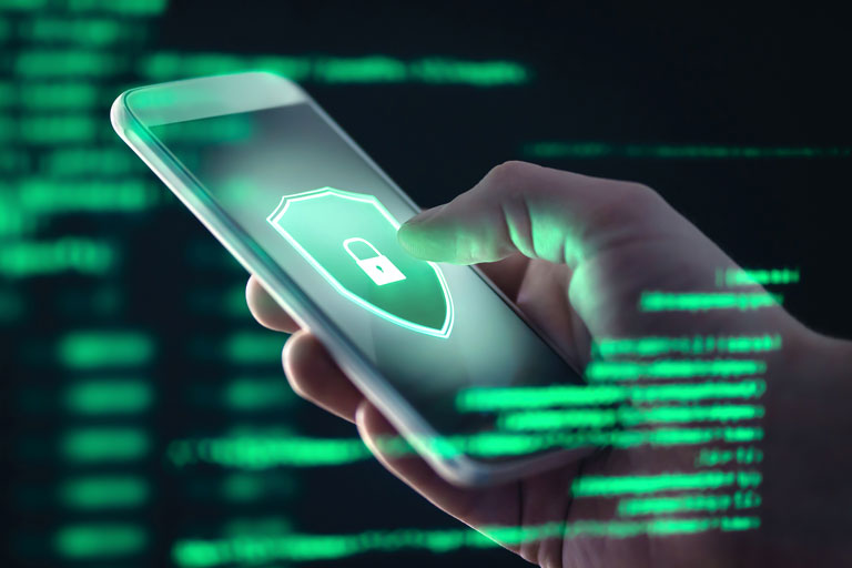 A lock symbol on a shield on a smartphone screen with green computer code around it reminiscent of the matrix. 