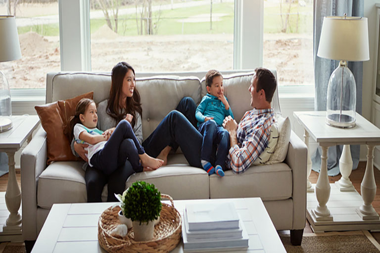 family relaxes on couch