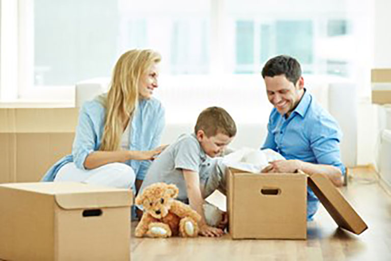 family unpacking moving boxes