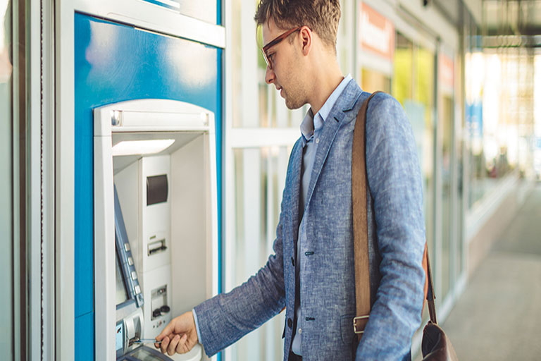 man uses ATM