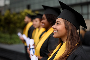 Students graduating holding diplomas