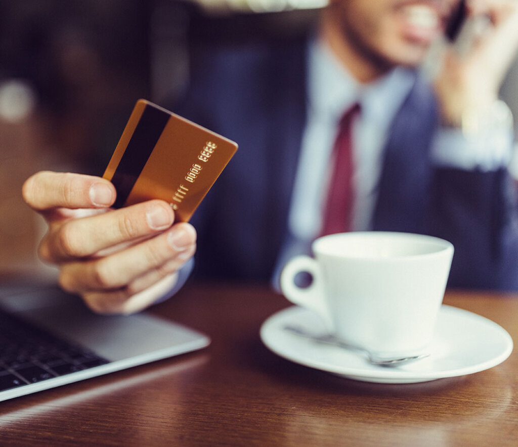 Man in business suit holding example credit card