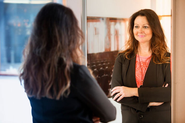 businesswoman admires herself in mirror