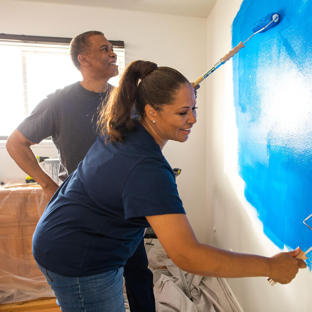 Couple painting a room wall blue