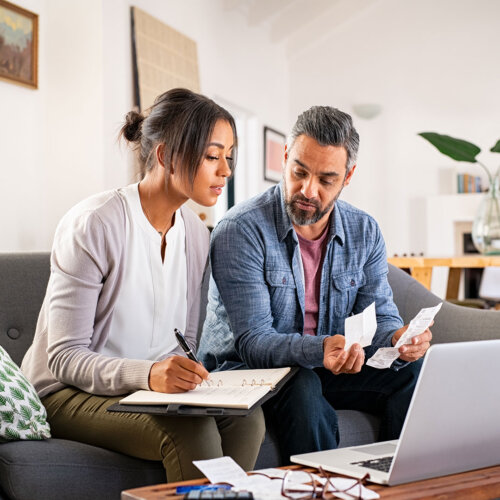 Couple on the couch doing taxes with receipts