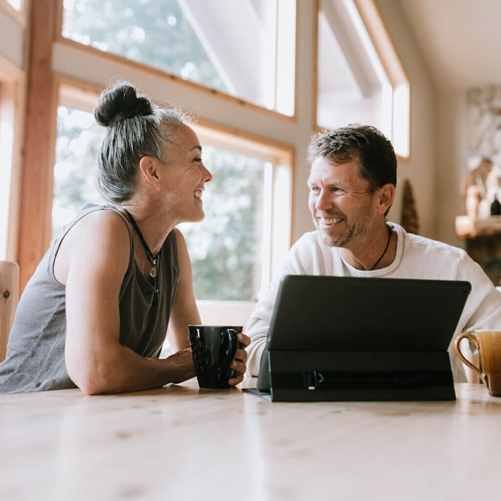 Couple sitting at the table looking at a tablet together