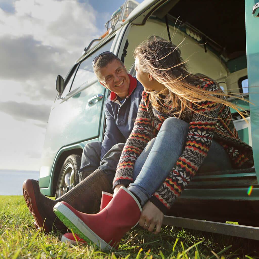 Couple putting on shoes in VW bus