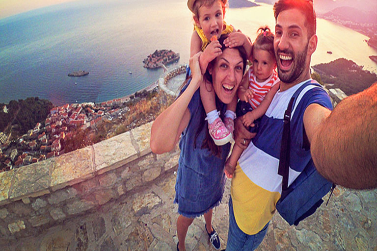 family takes selfie with coastal view