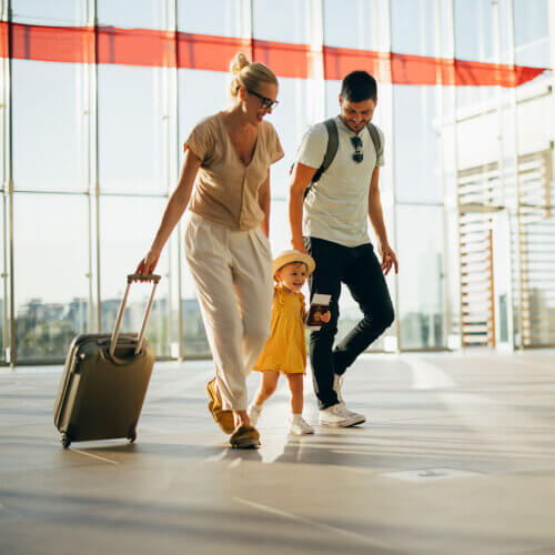 Family holding hands while walking through airport