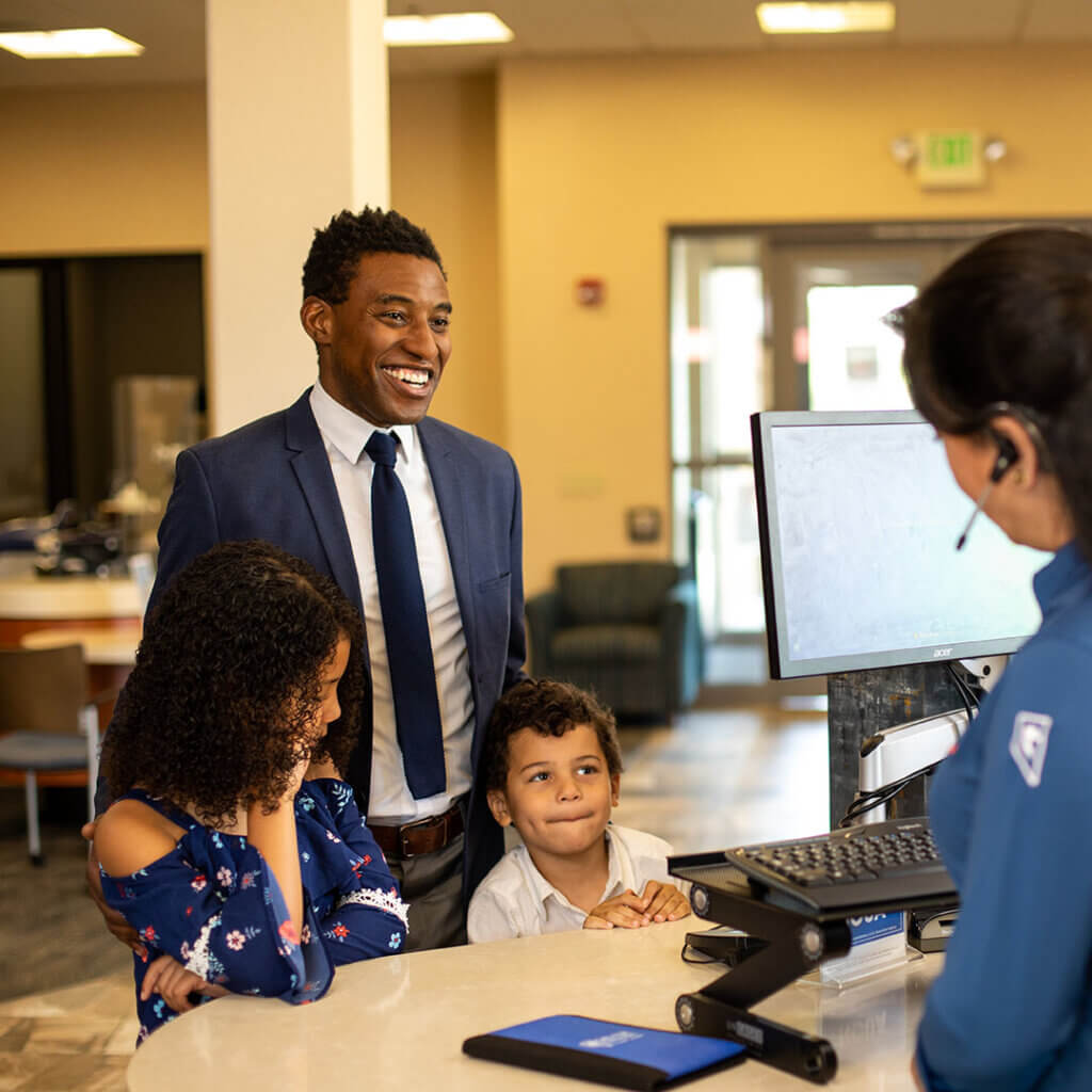 Family inside a branch at a pod with a Member Service Representative