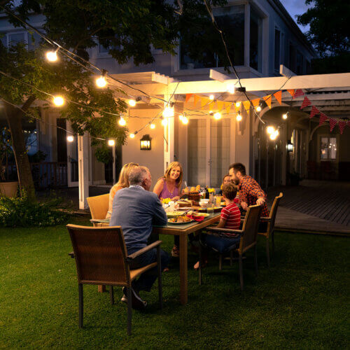 Family outside eating together under the lights