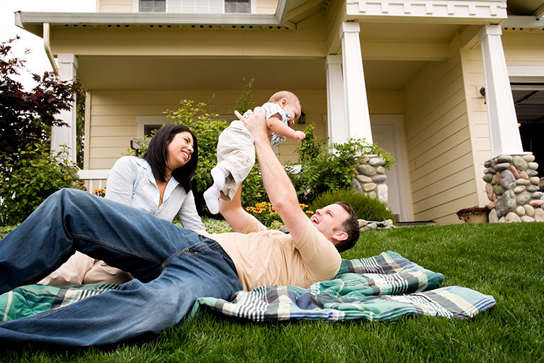 Family playing with their baby in front lawn