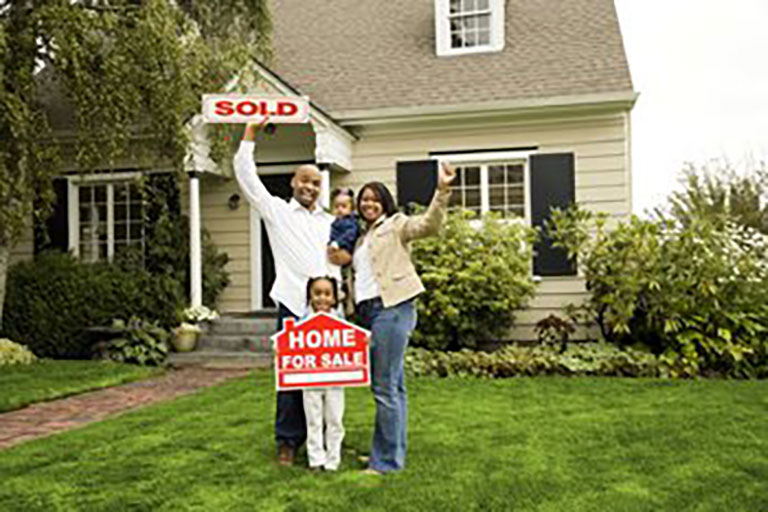 diverse family holding home for sale and sold signs