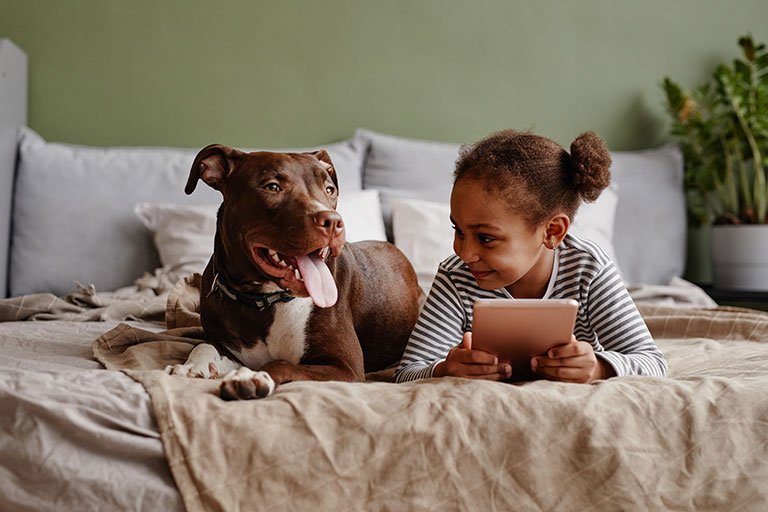 girl on bed with dog