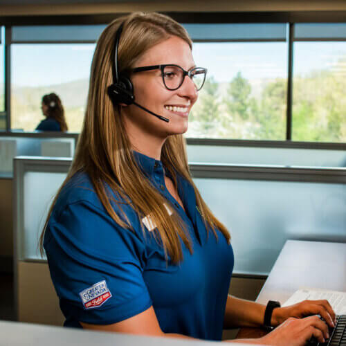 GNCU employee working on computer while smiling