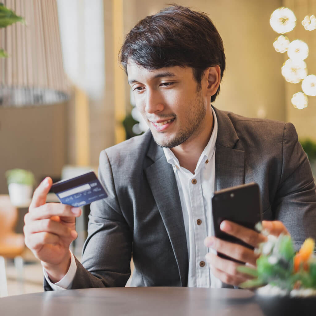 Man holding debit card and smartphone