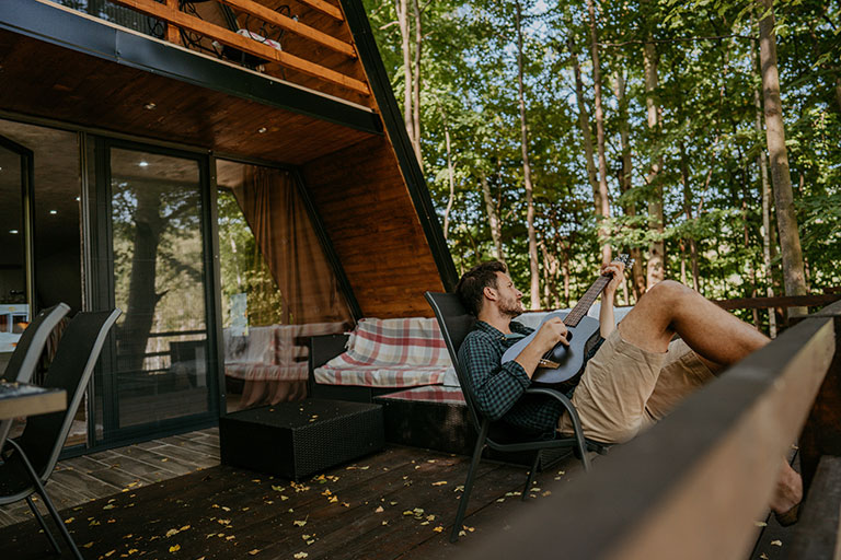 Man playing guitar on patio outside