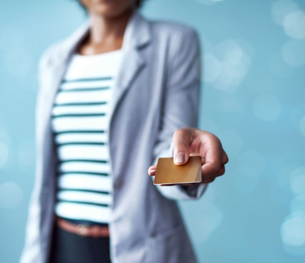 Woman holding an example credit card