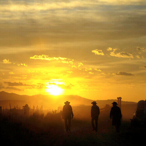 Ranchers walking in a sunset