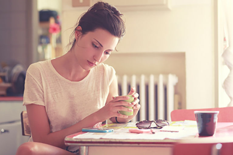 woman with serious expression sits at table