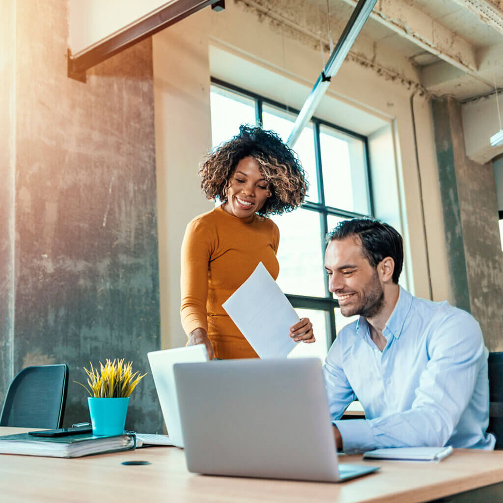 Small business employees together looking at laptops