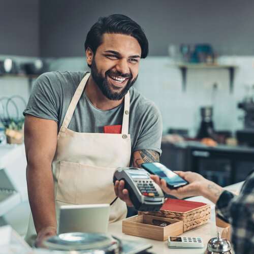 Small business employee taking a mobile wallet payment