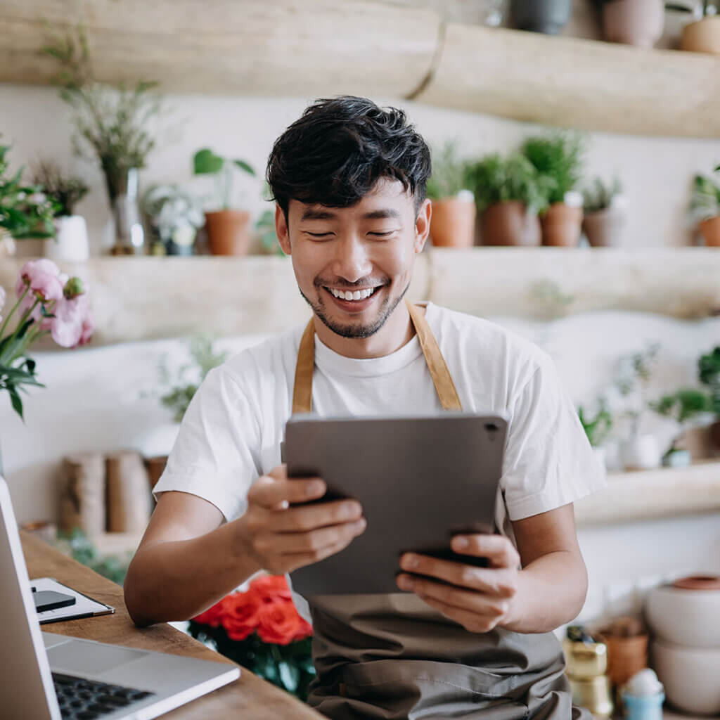 Small business owner looking happy while reading tablet