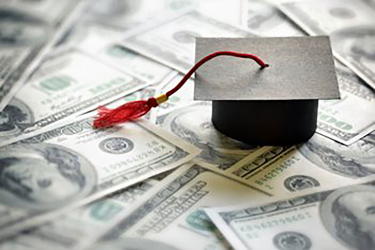 graduation hat on top of cash