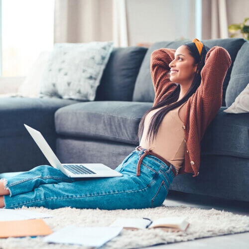 Woman on her laptop looking relieved and happy