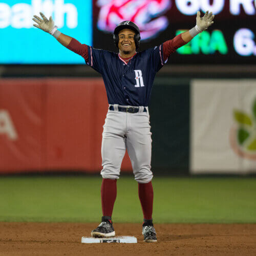 Reno Aces player with his hands up after stealing a base