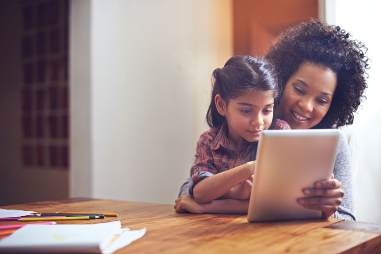 Mother and daughter taking a financial education class online on an tablet.