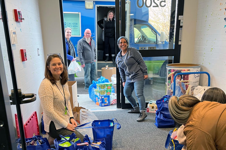 A hallway of GNCU staff volunteering to sort donations to get them ready for KTVN's Share Your Christmas drive-by food drive.  