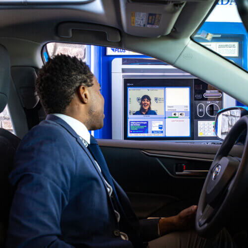 Man talking with a Member Service Representative at an Interactive Teller Machine (ITM)