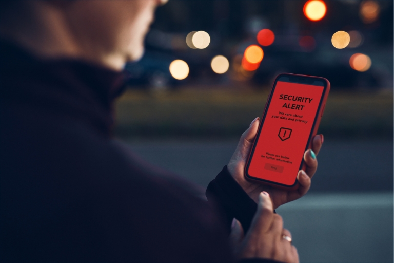 A man receiving an account alert on his smart phone.  