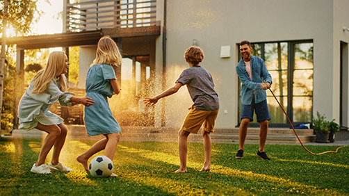 Family having a water fight in the backyard