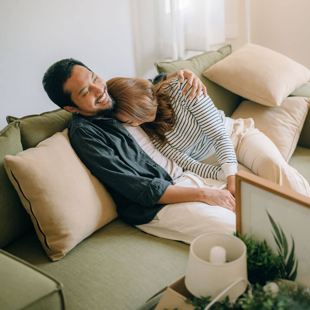 Couple hugging and resting together on a couch while moving
