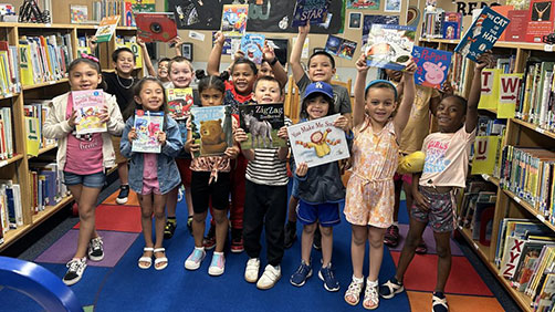 Group of children holding books excitedly