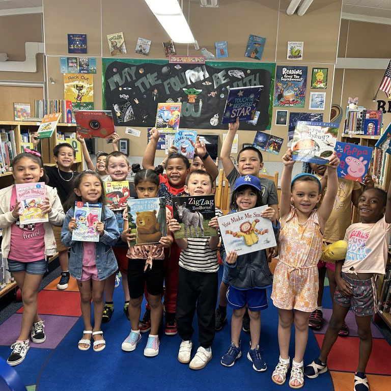 Group of children holding books excitedly