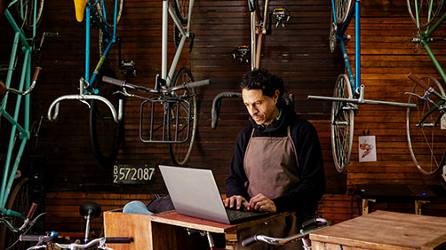 Small business bike shop owner working on a laptop