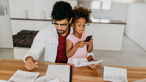 Dad and daughter looking at bills together